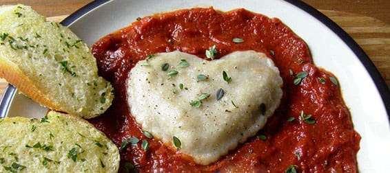 heart-shaped ravioli in tomato sauce with garlic bread