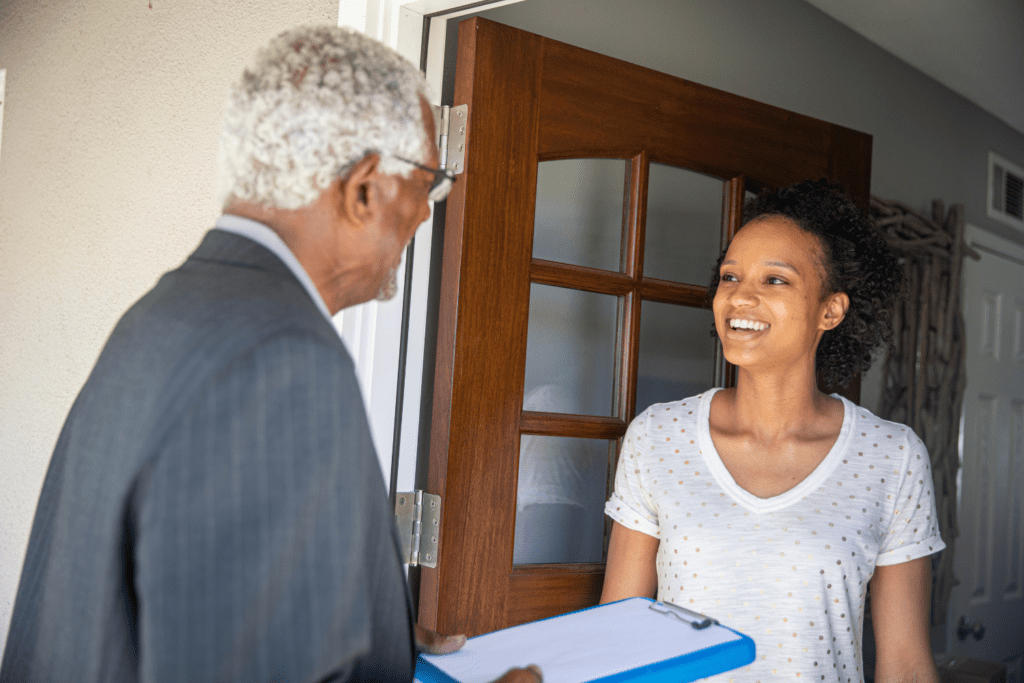 A door-to-door canvaser speaks with a person at their front door