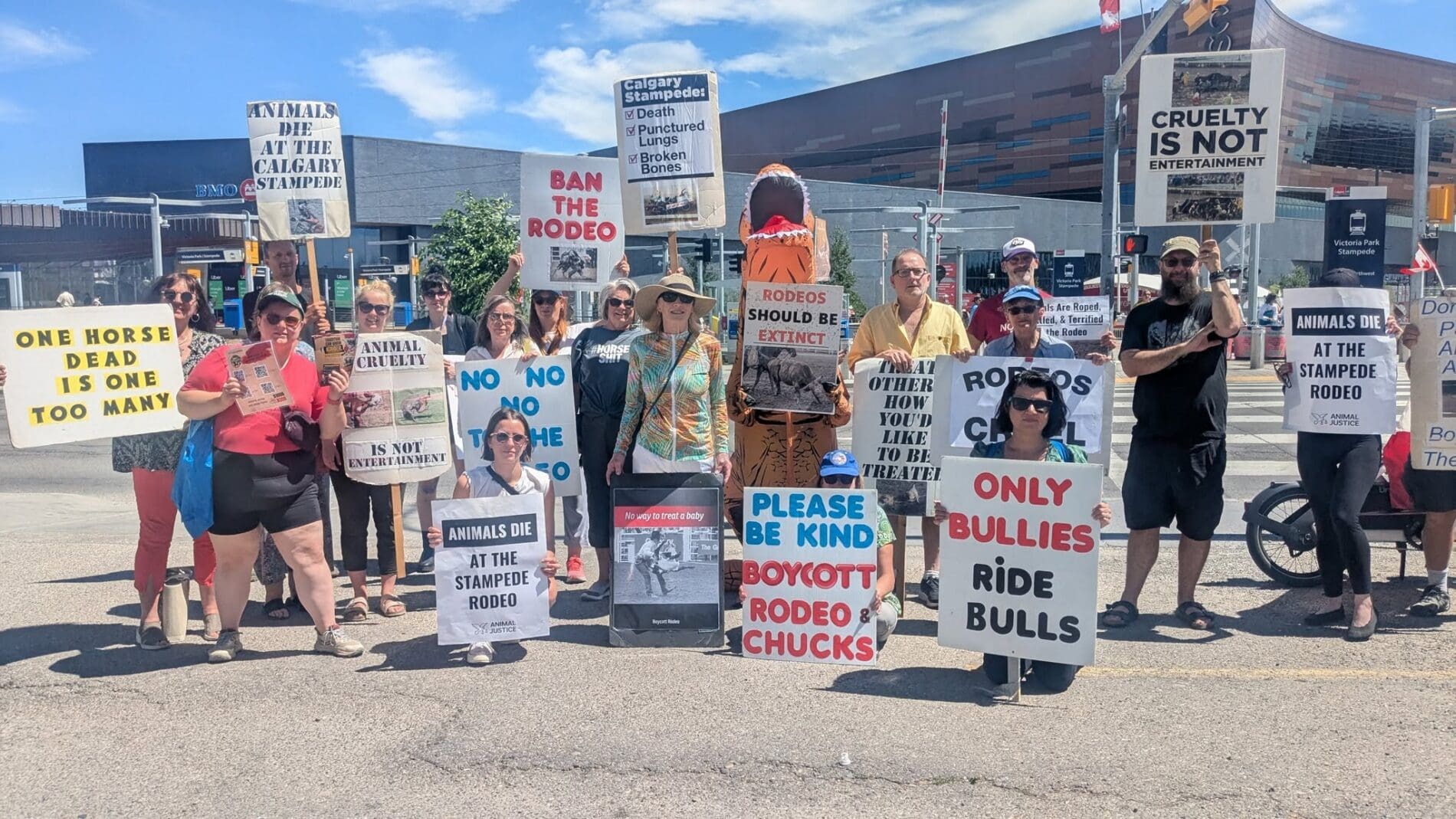 Dozens of activists gather with signs protesting the 2026 Calgary Stampede