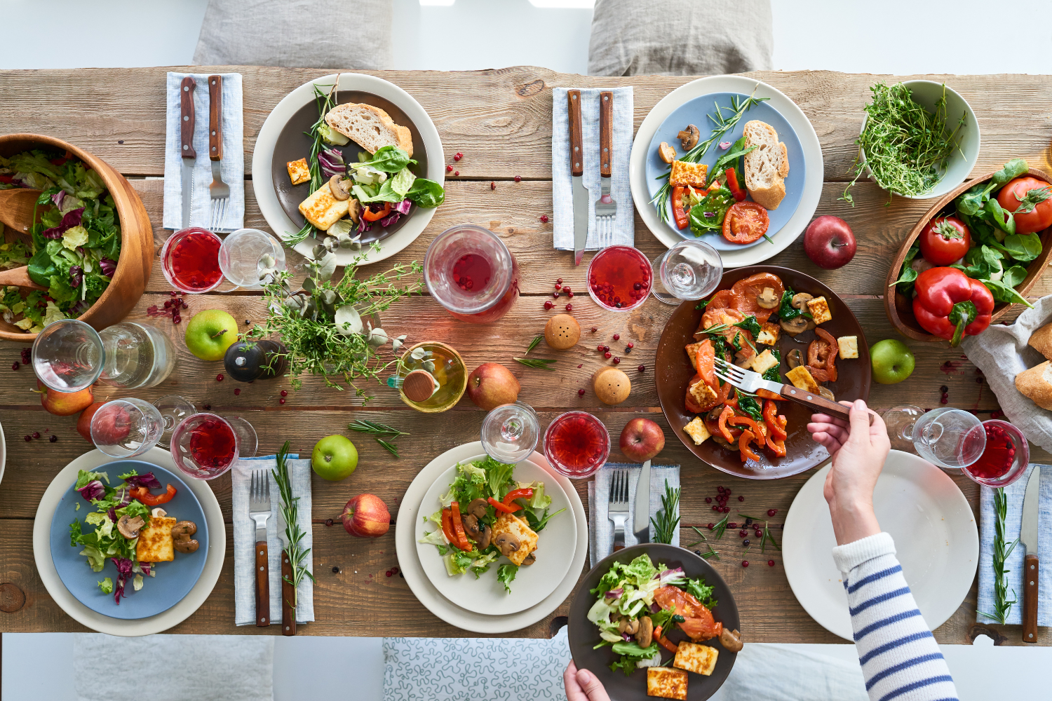 An overhead view of a wooden table set with colorful plant-based dishes.